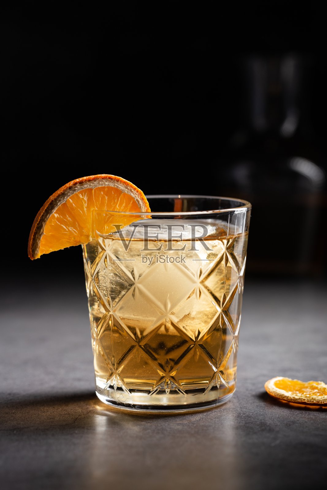垂直镜头的一杯威士忌装饰了一片干橙照片摄影图片