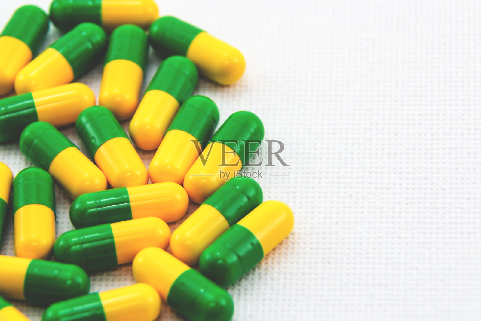 白色表面上黄色和绿色胶囊的高角度特写镜头照片摄影图片