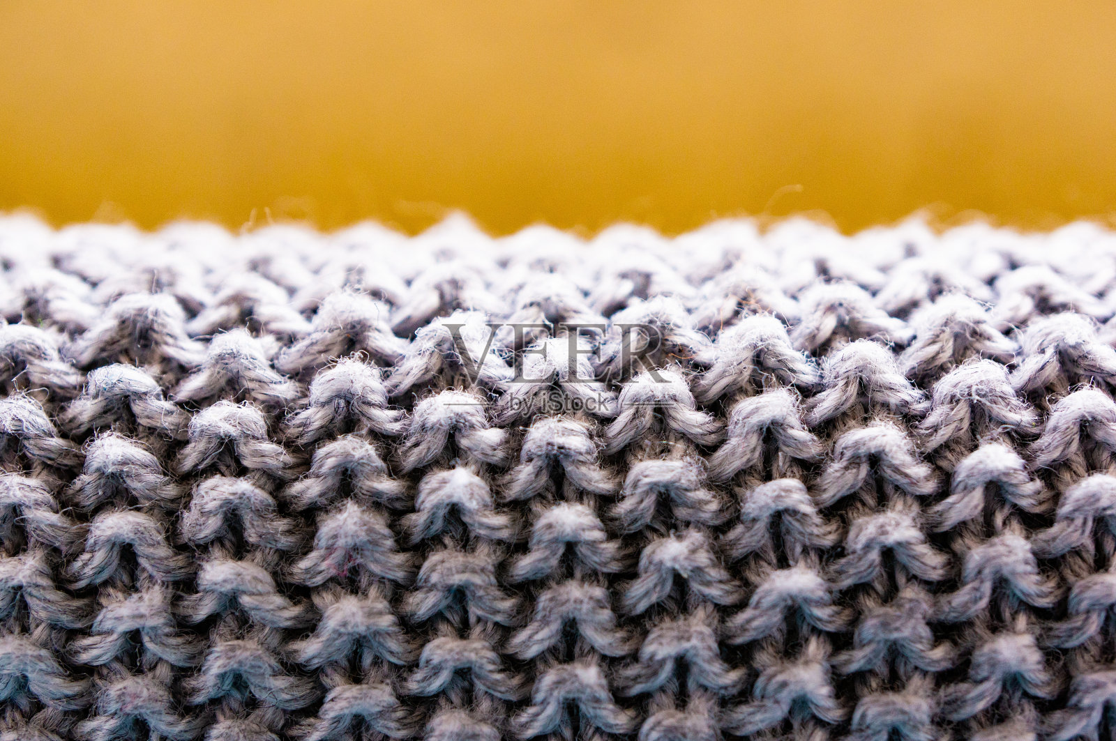 特写镜头的灰色蓬松的纺织品与模糊的棕色背景照片摄影图片