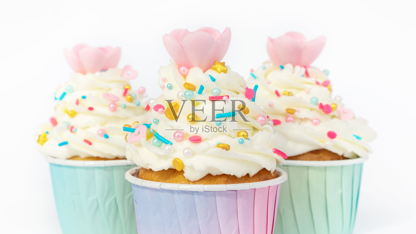 奶油纸杯蛋糕，白色背景上有金色的特写。节日甜点与华夫饼花装饰优雅的婚礼，周年纪念，儿童聚会。照片摄影图片