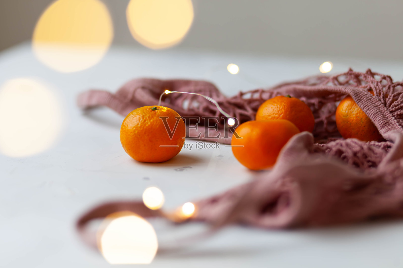 桔子装在粉红色的绳袋里照片摄影图片