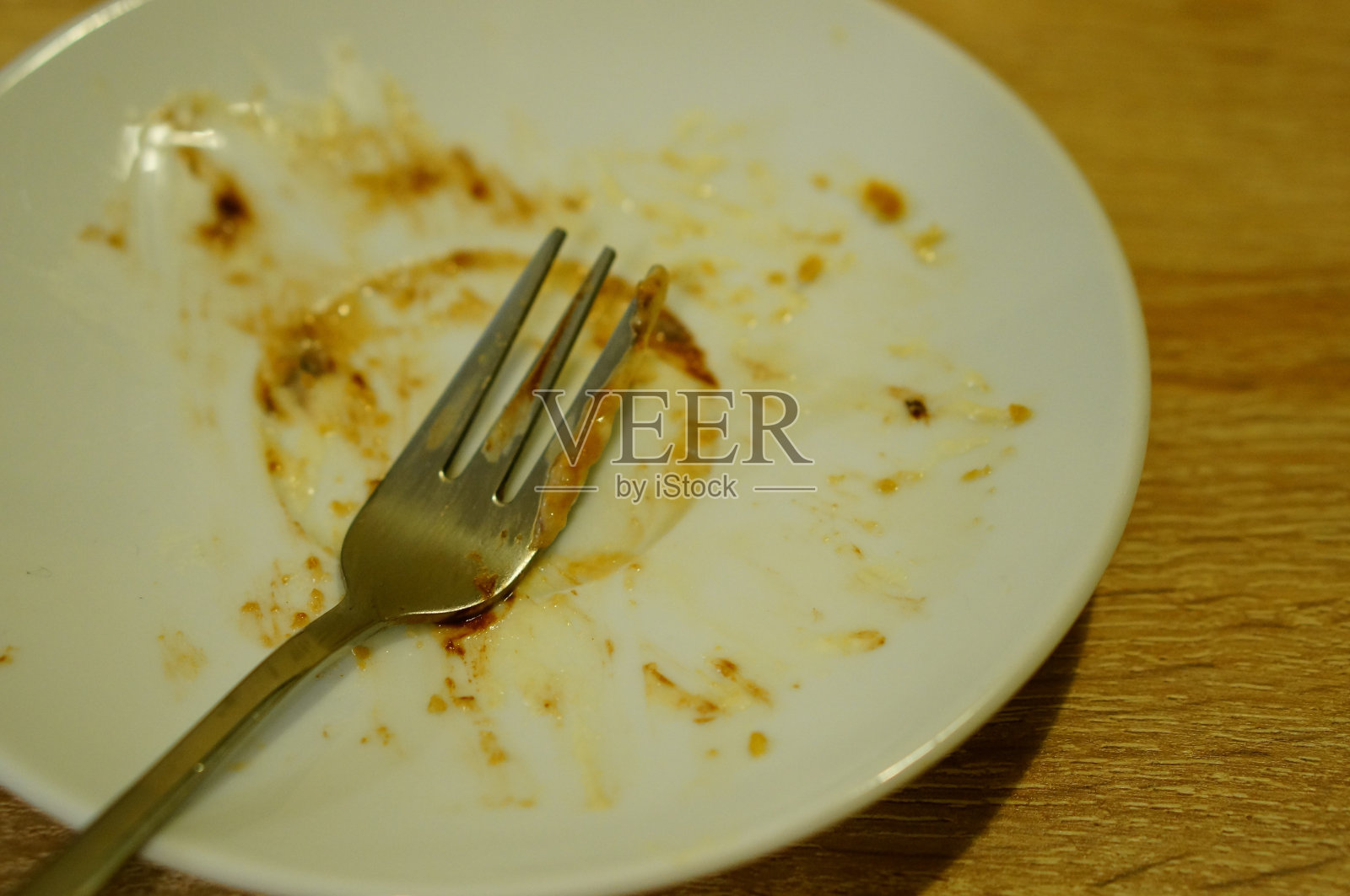 叉子放在脏兮兮的白色小盘子上照片摄影图片