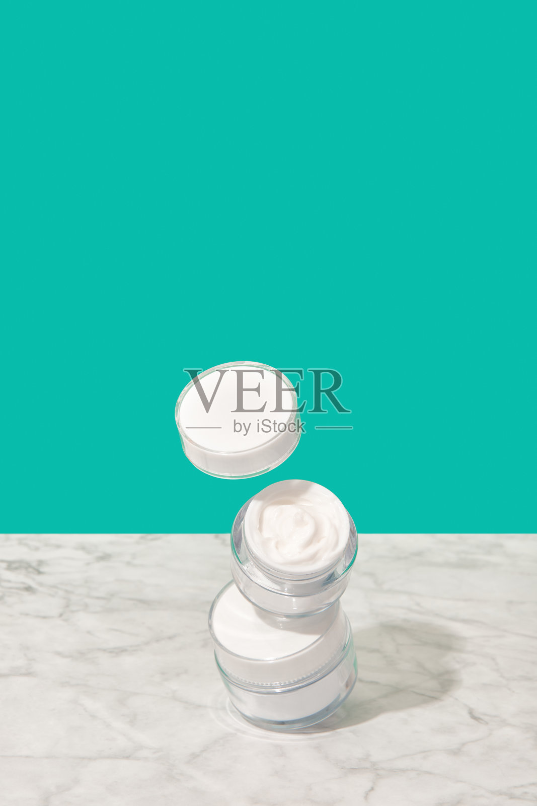 平衡罐与化妆品霜在蓝绿色的背景照片摄影图片