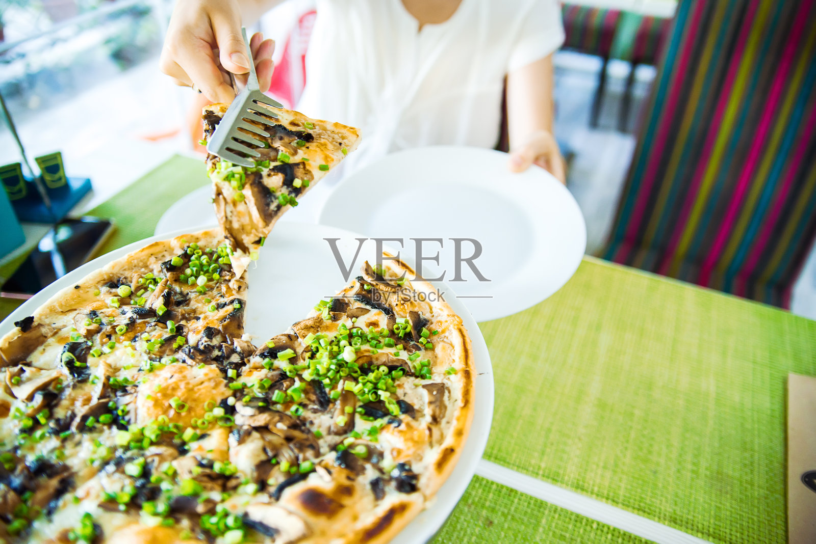 片披萨。餐馆里有披萨的桌子。披萨在绿色上的特写照片摄影图片