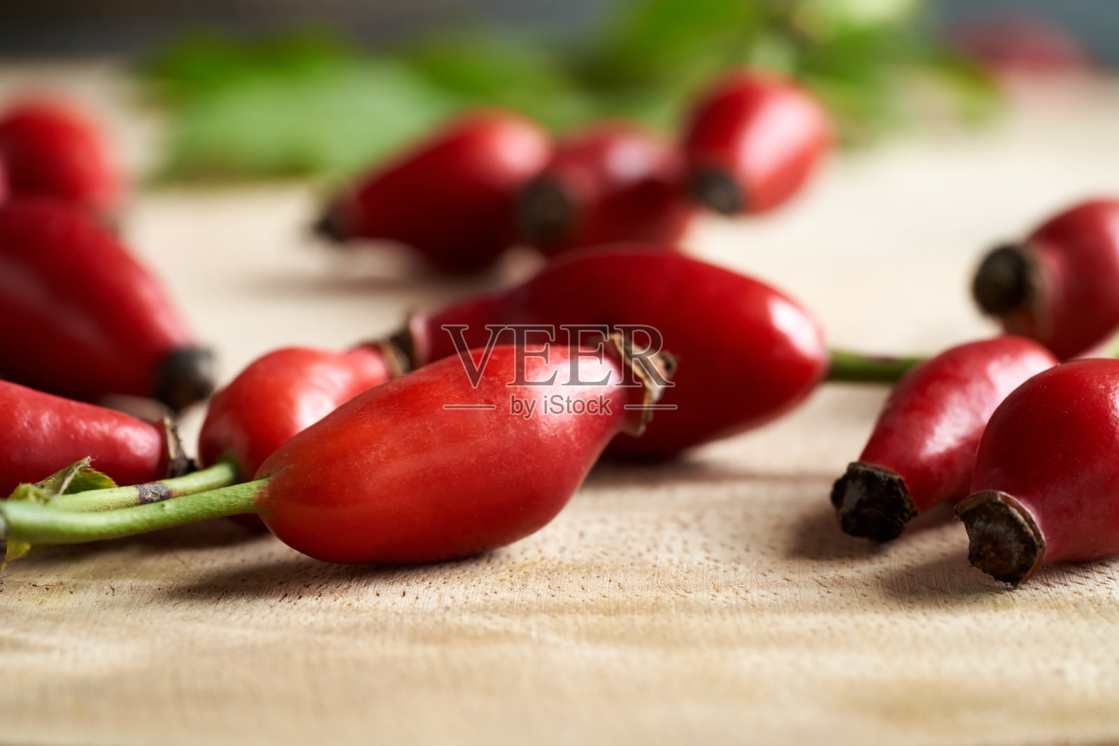 木桌上放着新鲜的玫瑰果照片摄影图片