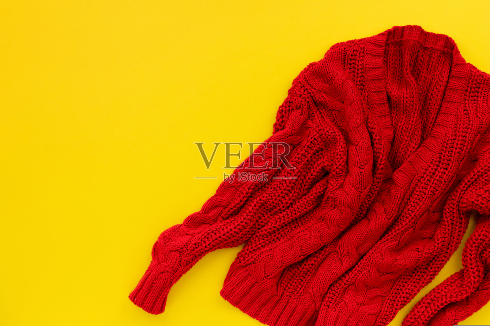 黄色背景下的红色毛衣。平铺俯视图照片摄影图片