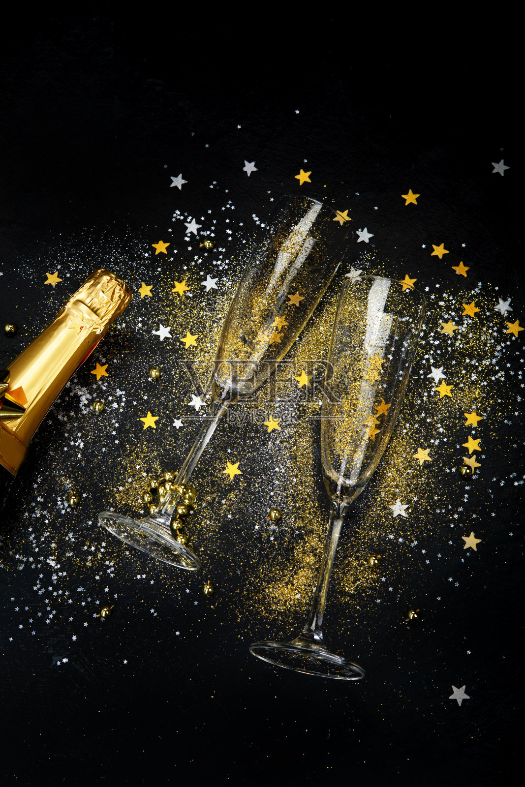 一杯香槟和一瓶在黑暗的背景。照片摄影图片