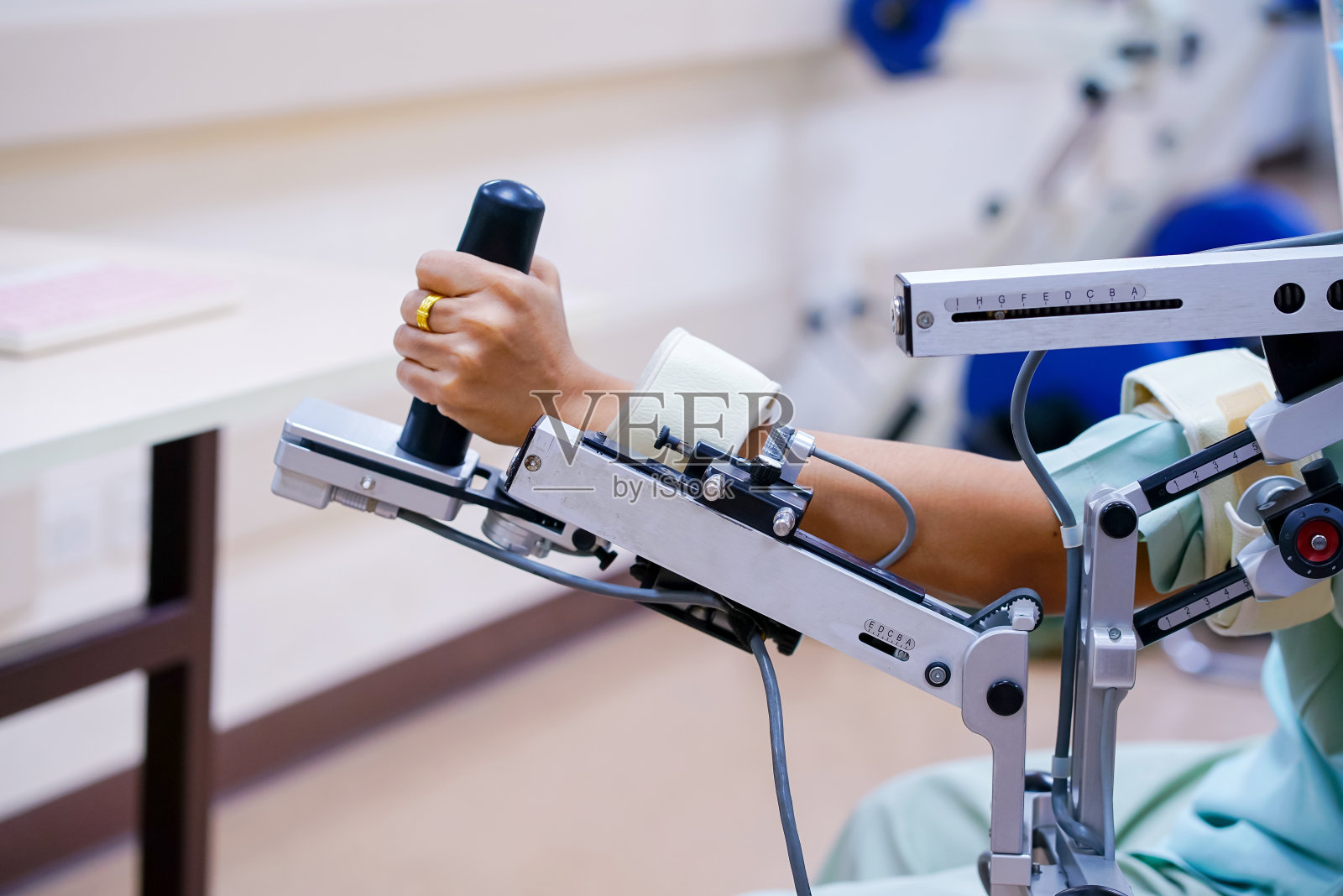 妇女佩戴机械臂进行物理治疗。通过定义如何改进机器人驱动的移动技术，以达到更好的物理康复效果照片摄影图片