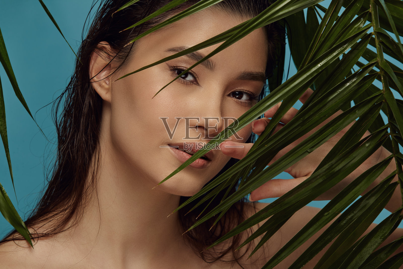 亚洲美丽的女孩站在热带植物的叶子。照片摄影图片