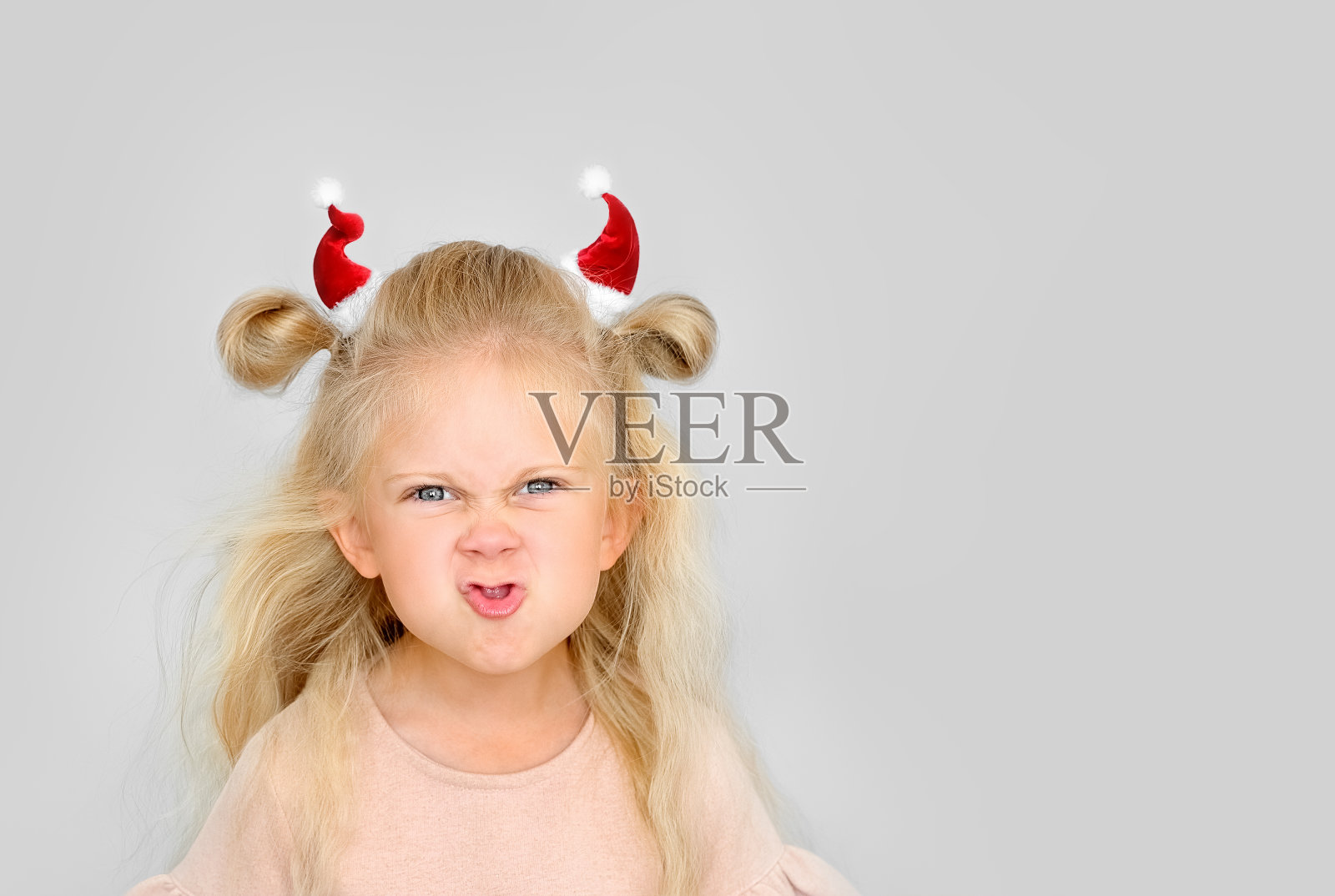 圣诞老人帽子上戴着牛角的小女孩肖像照片摄影图片