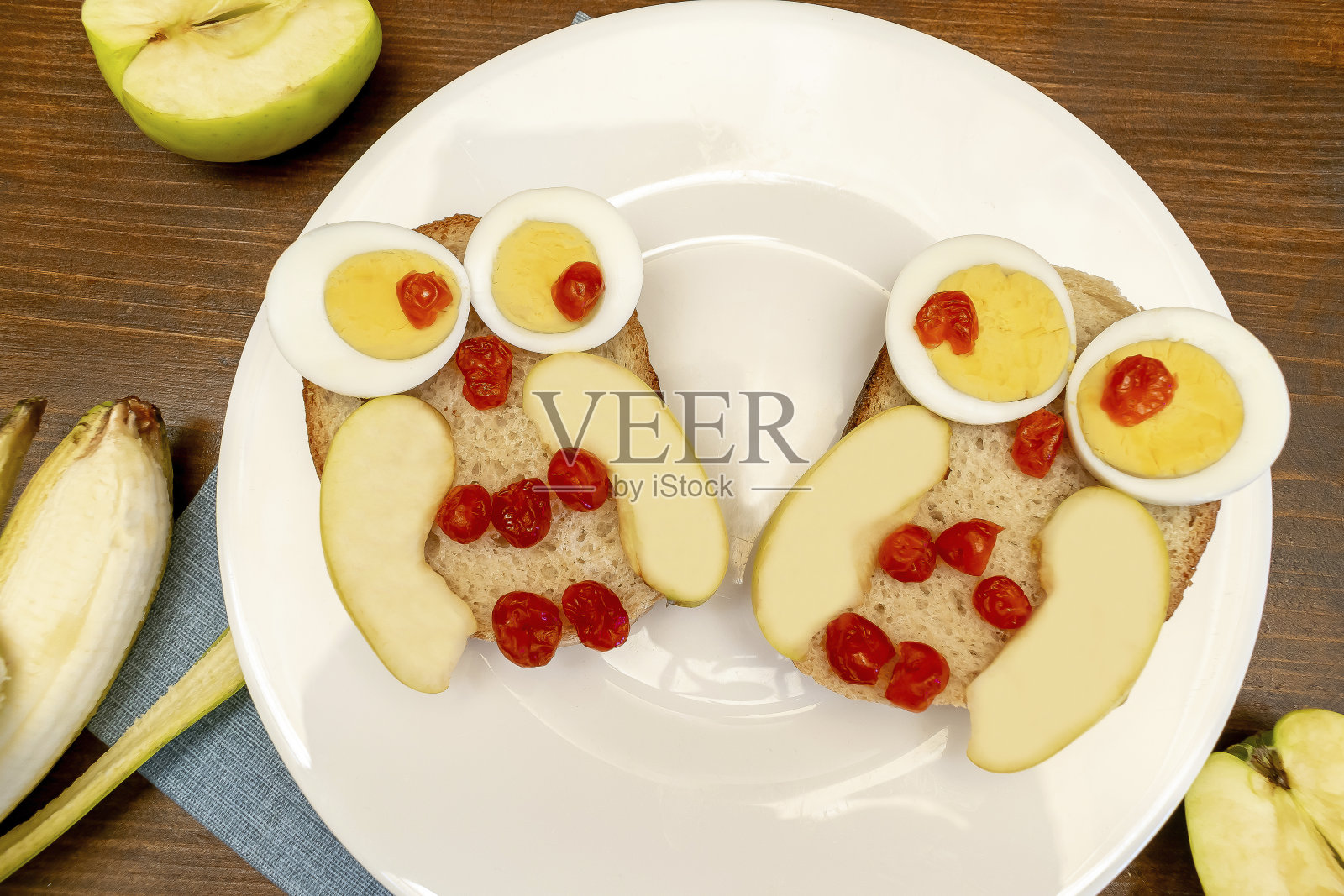 有趣的猫头鹰脸三明治吐司面包与鸡蛋，苹果，香蕉，干浆果水果盘。可爱的孩子孩子宝宝的甜点早餐，午餐，食物艺术在木制背景，俯视图照片摄影图片