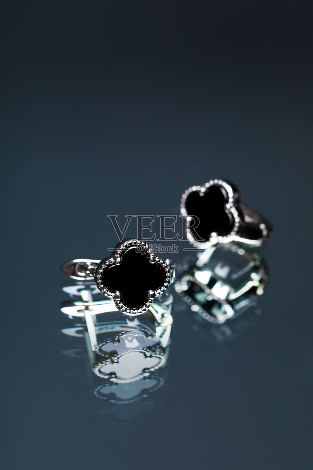 黑色背景的黑色珐琅耳环照片摄影图片