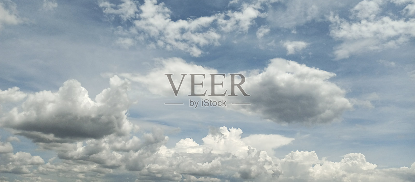 晴朗的天空。天上飘着白云。水平的观点。照片摄影图片