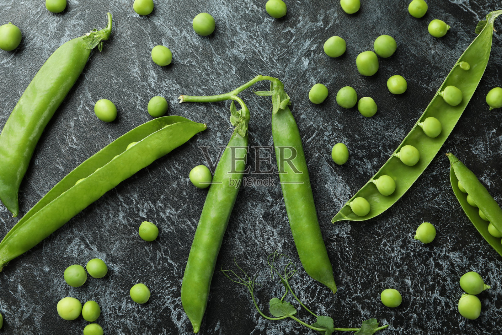 新鲜的绿色豌豆在黑烟背景照片摄影图片
