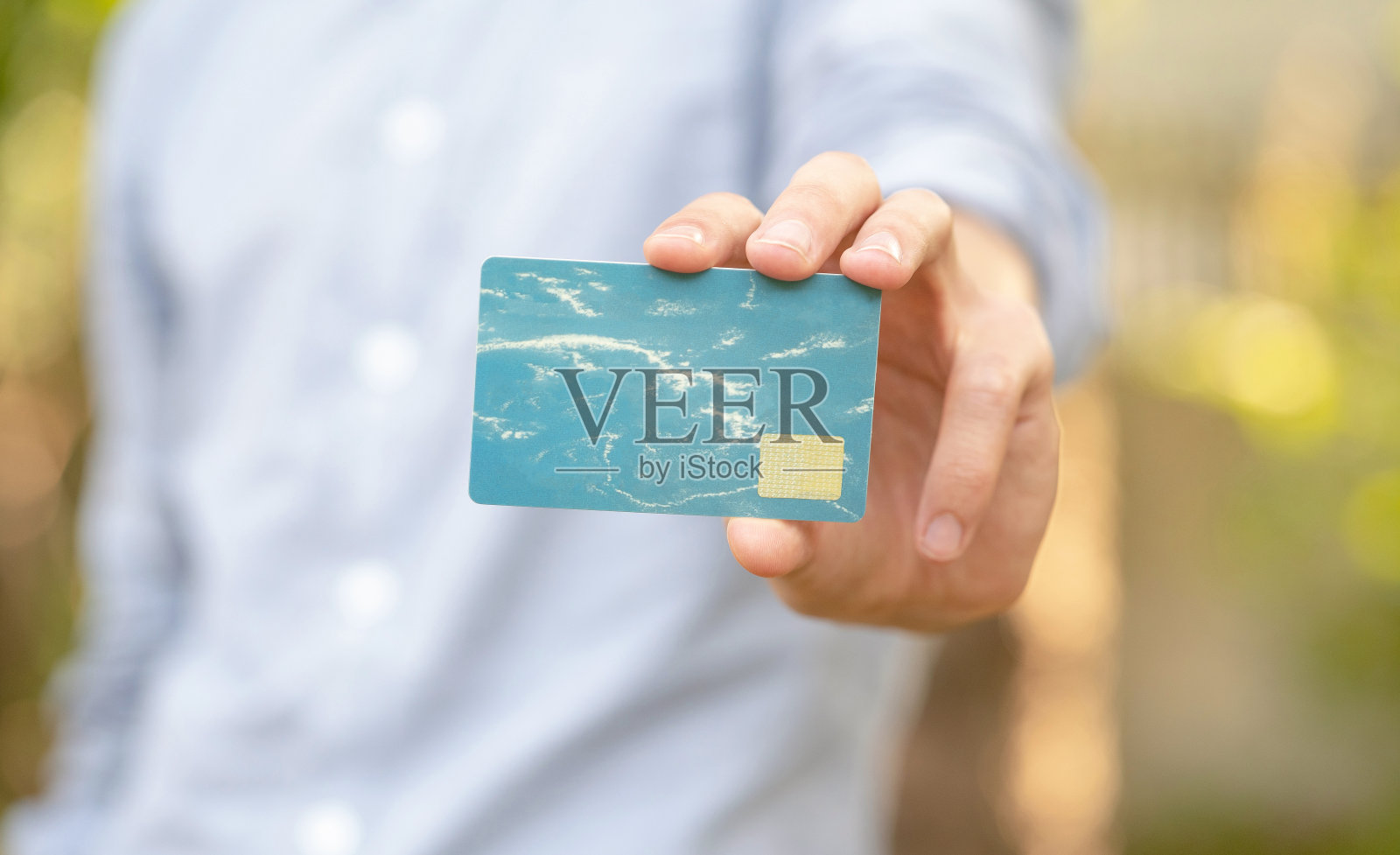 男人手里拿着一张简单的空白塑料信用卡或礼品卡，对着相机，复制空间，浅景深，现代设计。赠送，赠送，展示俱乐部卡的概念照片摄影图片