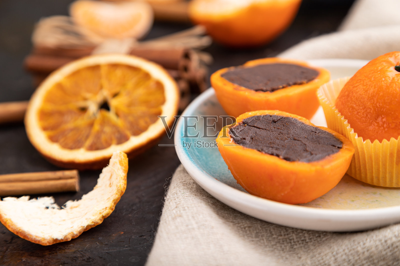 黑色混凝土背景上的松露巧克力橘子糖果。侧视图，选择性聚焦。照片摄影图片