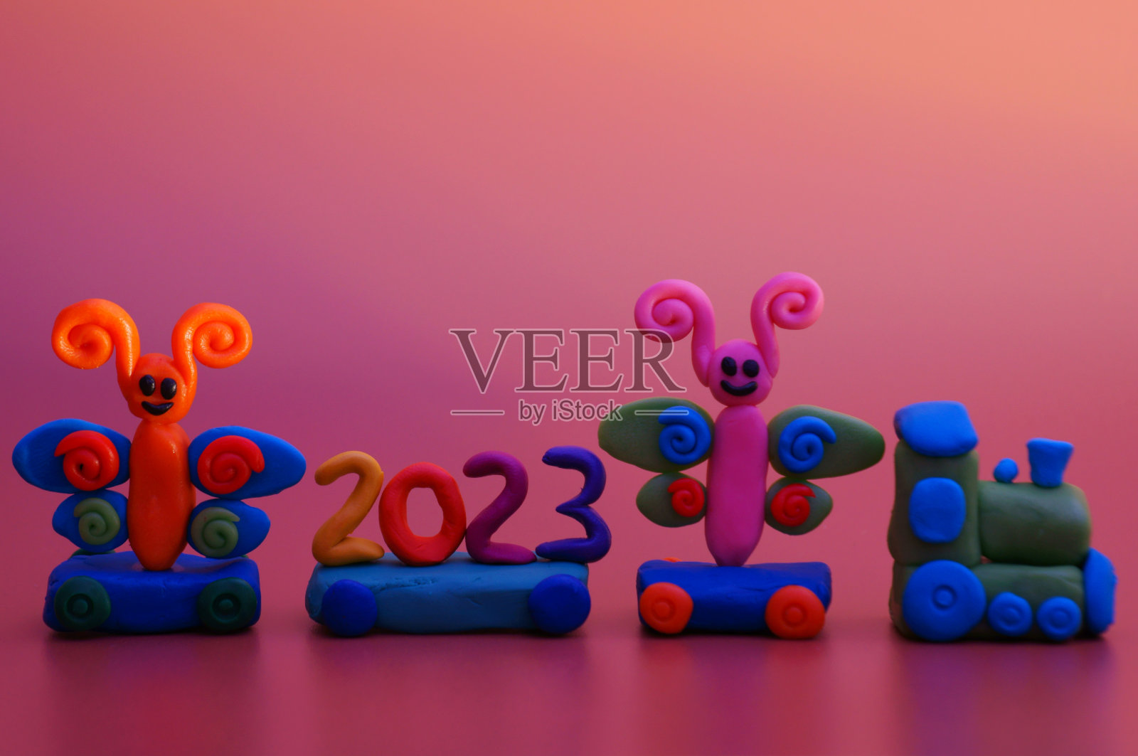 一辆玩具火车，上面有许多神奇的人物和数字2023。照片摄影图片