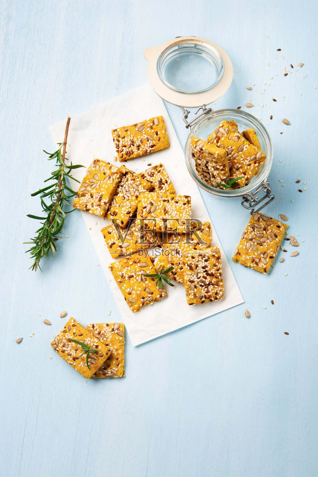 无麸质自制薄脆饼干和迷迭香为开胃蓝木背景。照片摄影图片