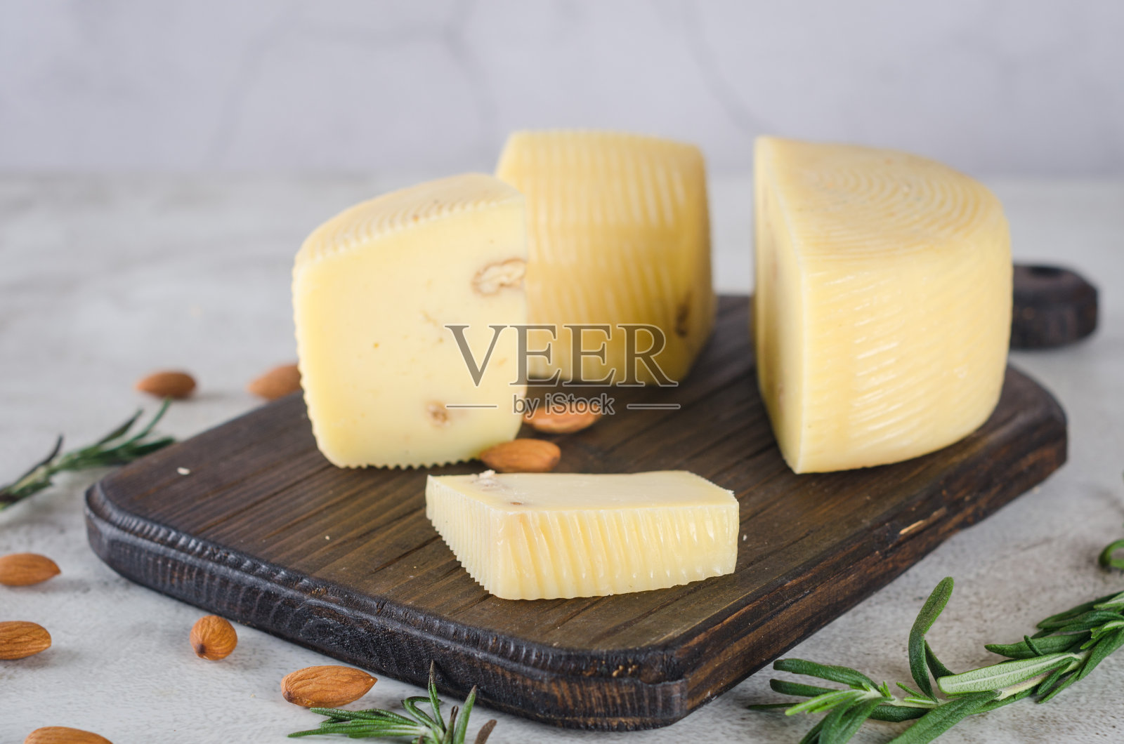 各种各样的奶酪头和块放在木板上照片摄影图片