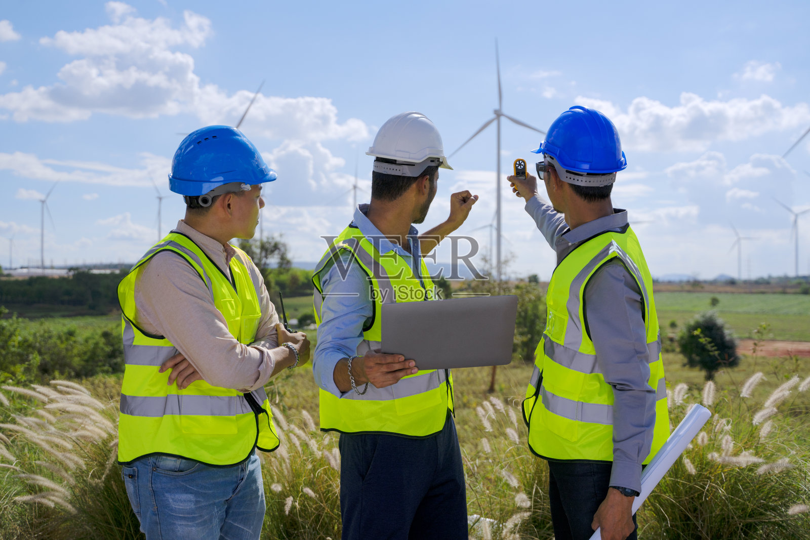 在电力工地的蓝领工人与风车照片摄影图片