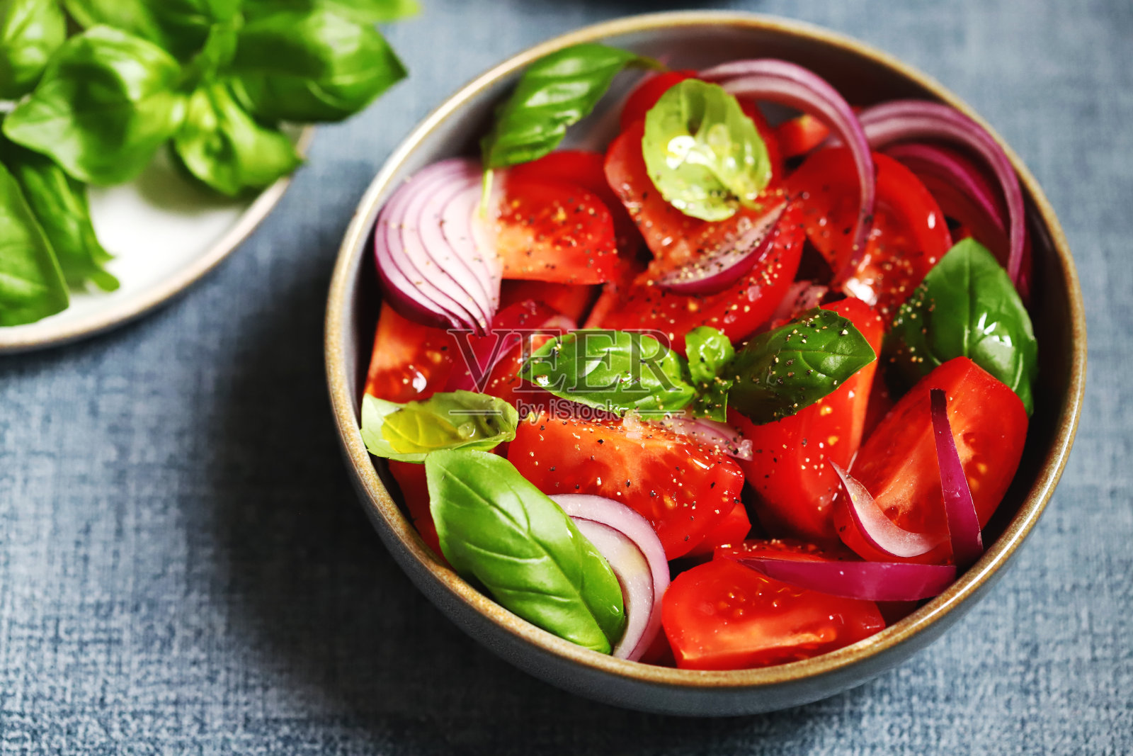 有番茄、罗勒和蓝洋葱的健康沙拉。照片摄影图片