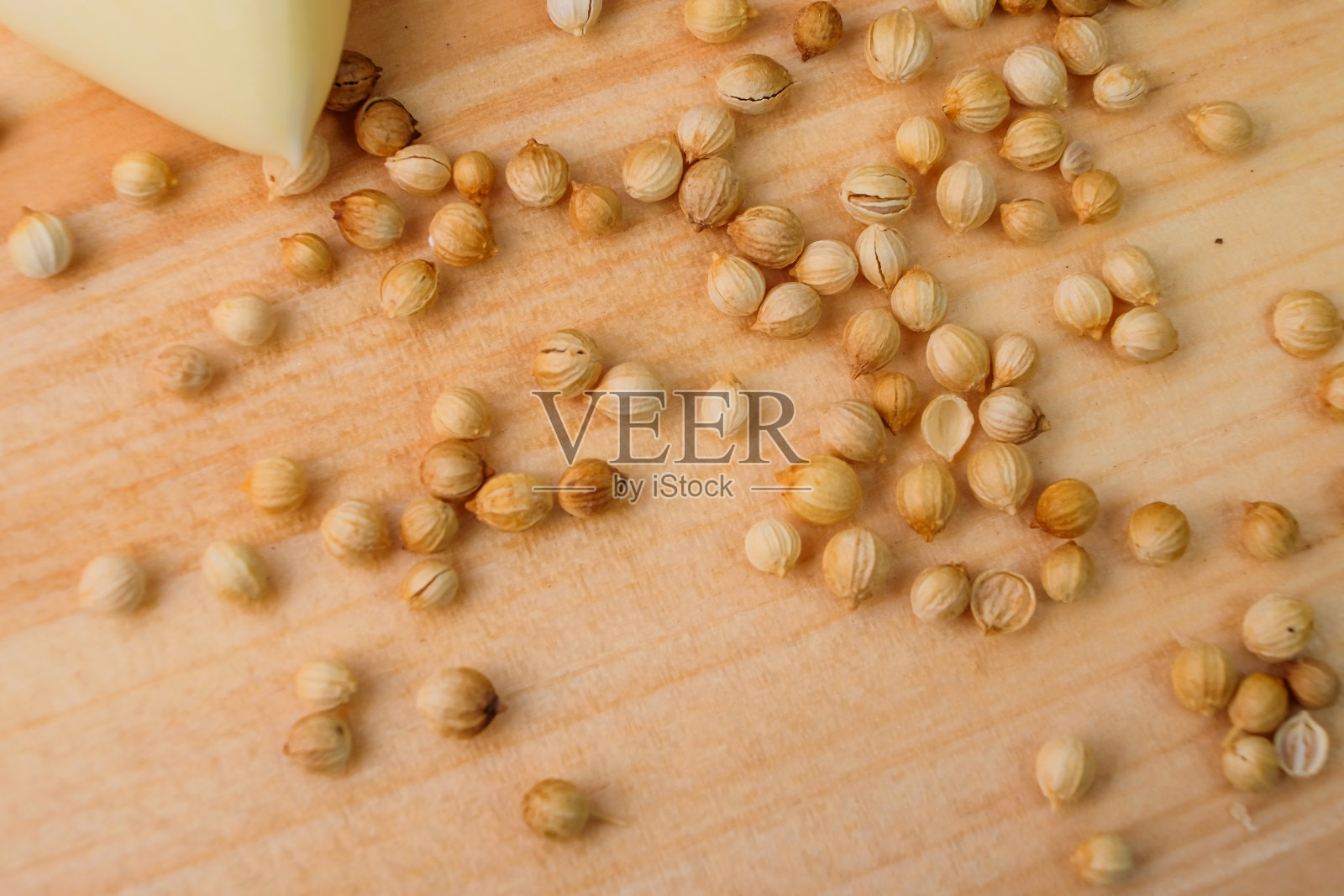 香菜种子撒在木砧板上。有特殊香气的调味料照片摄影图片