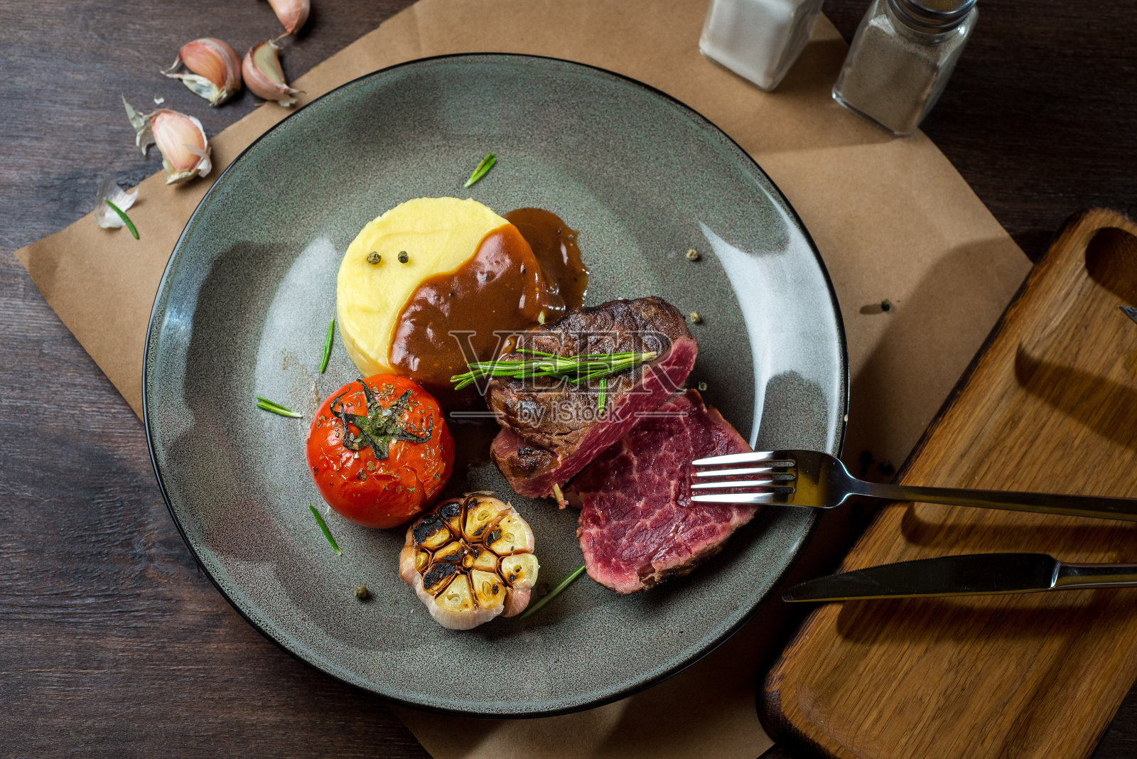 菲力牛排配土豆泥，烤番茄和大蒜，配上迷迭香。油炸程度不高。一块多汁的牛里脊肉照片摄影图片