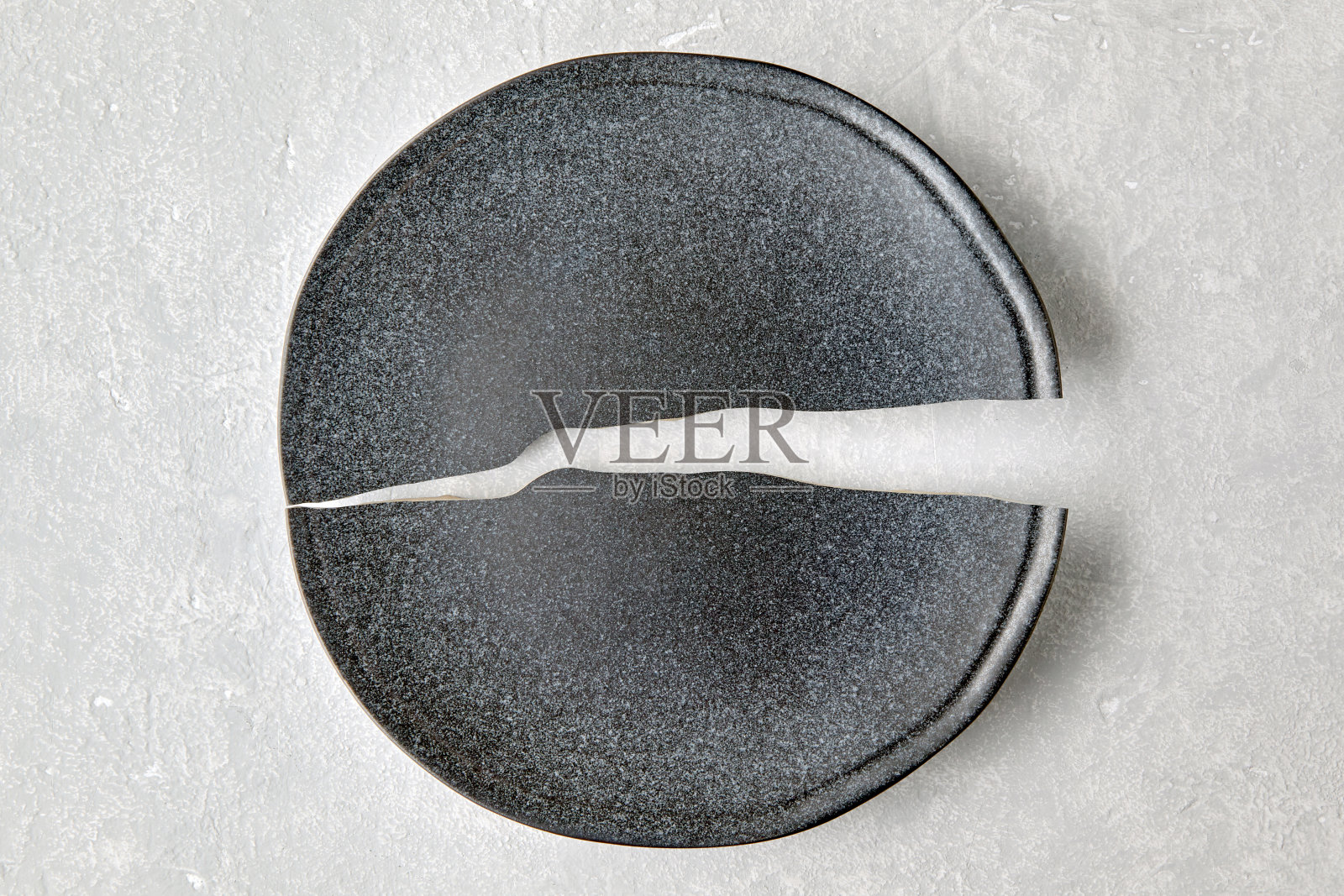 碎盘子放在浅灰色的混凝土桌上。破碎的梦照片摄影图片