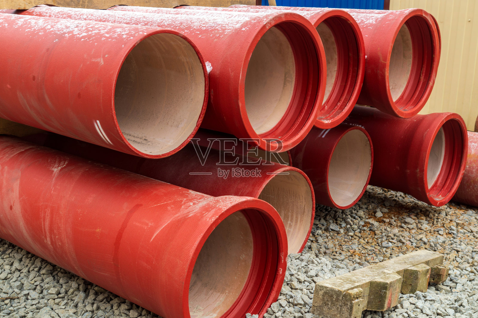 装修期间，橙色陶瓷水管堆放在街道上照片摄影图片