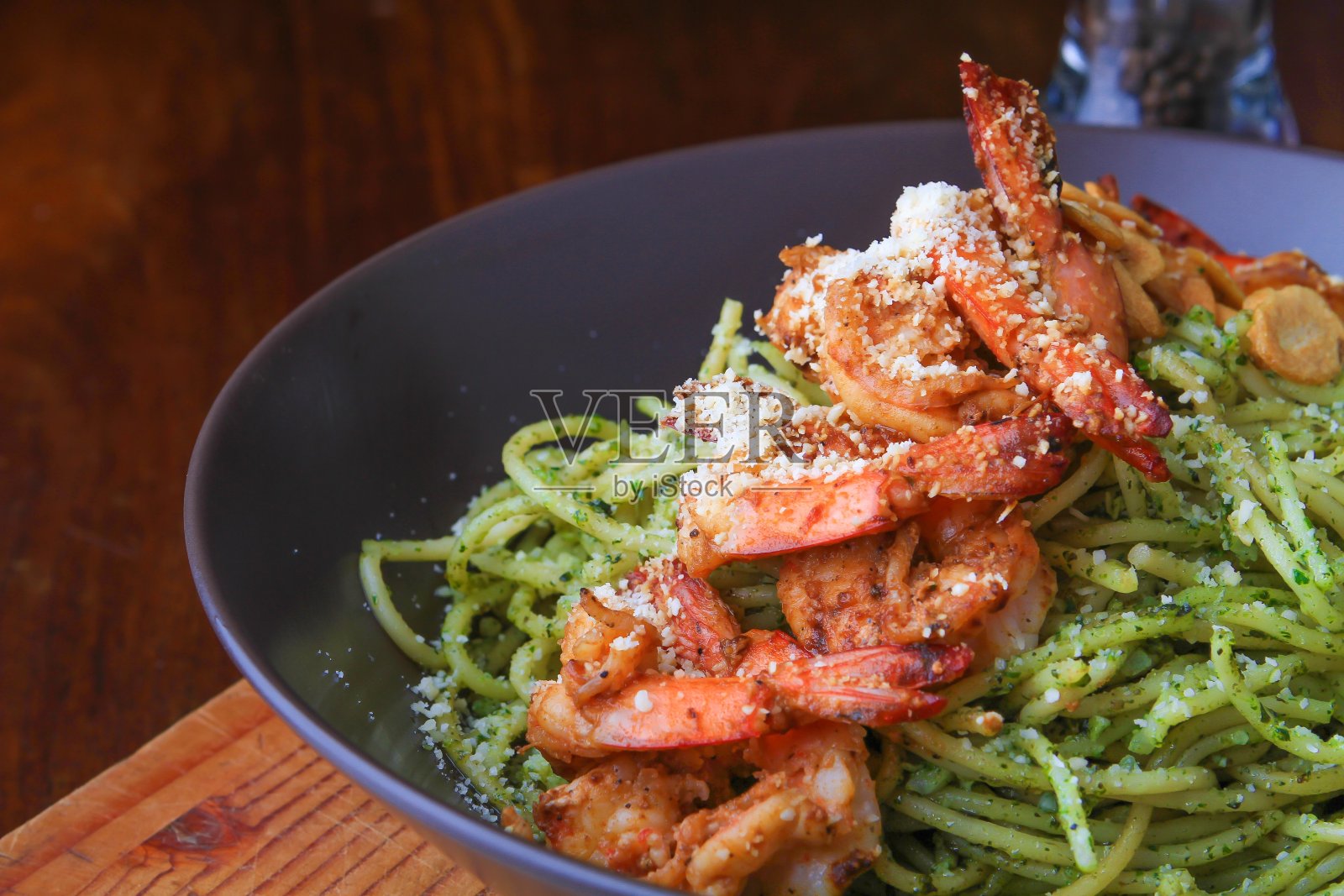 意大利面条，上面有肉片和帕尔马干酪，装在黑色盘子里照片摄影图片