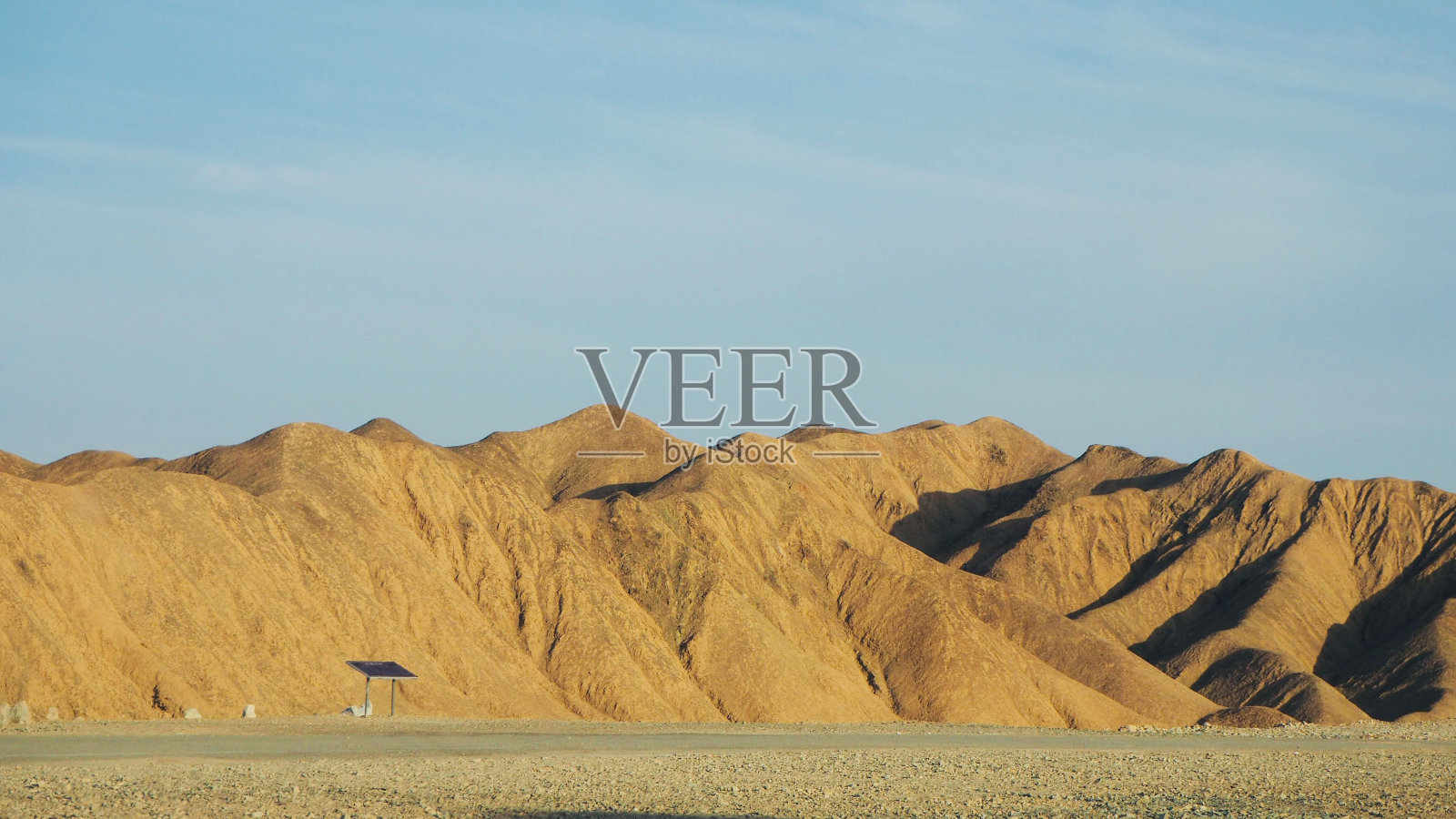 低角度的阳光照耀的山丘在地平线上，清澈的天空背景照片摄影图片