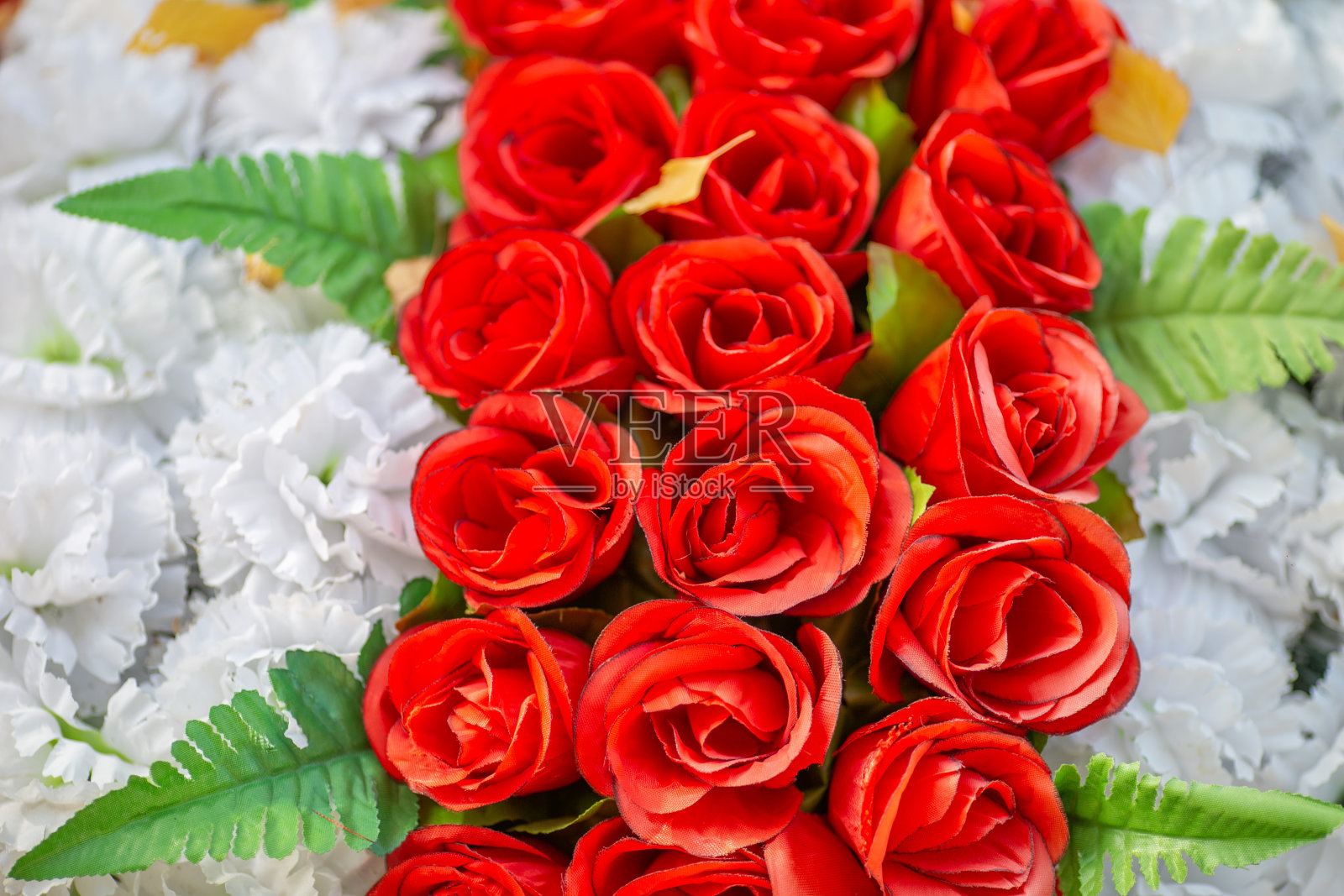 葬礼花圈上的人造红玫瑰和白色花朵照片摄影图片