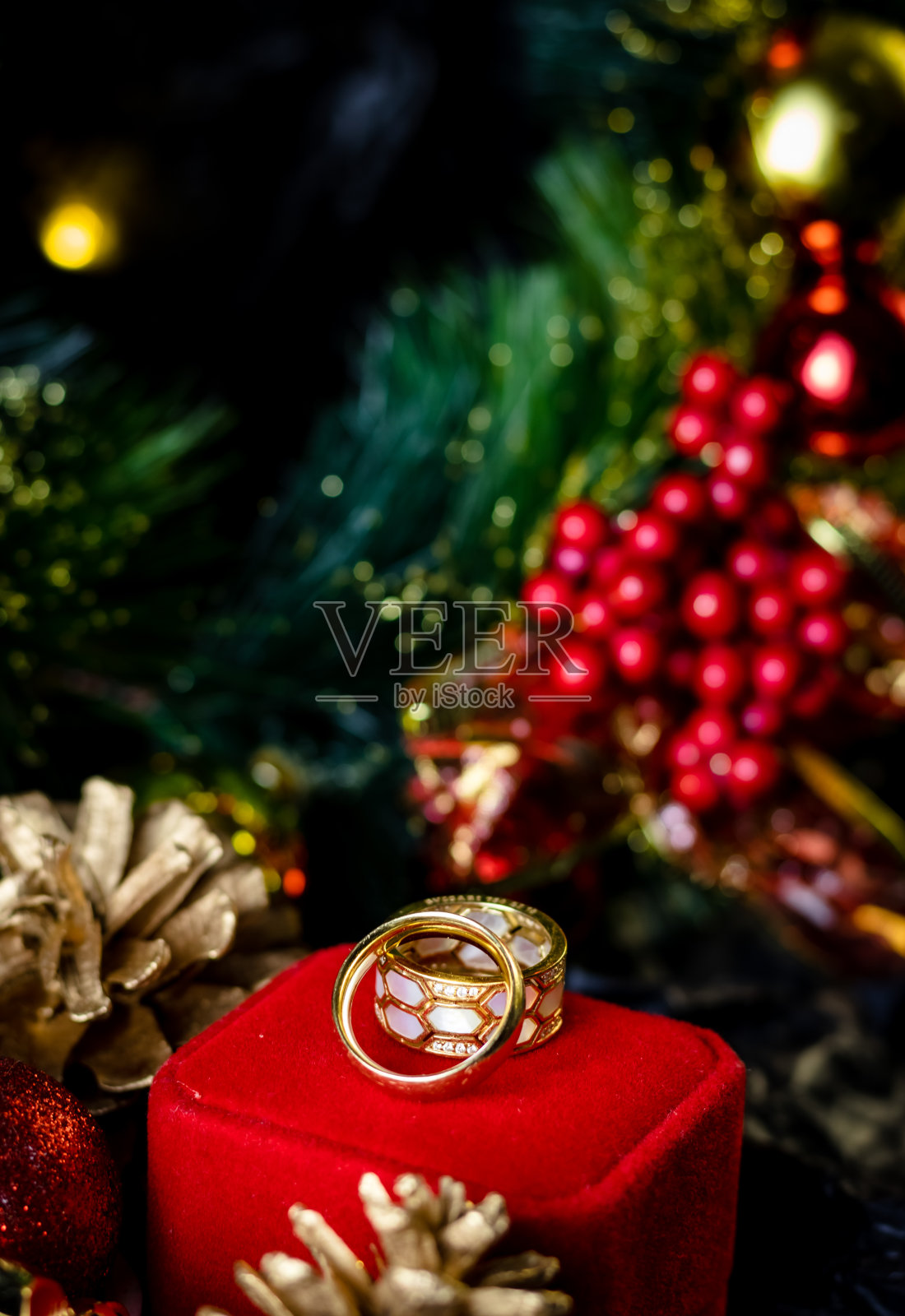 金戒指放在红盒子里做圣诞礼物，圣诞装饰品照片摄影图片