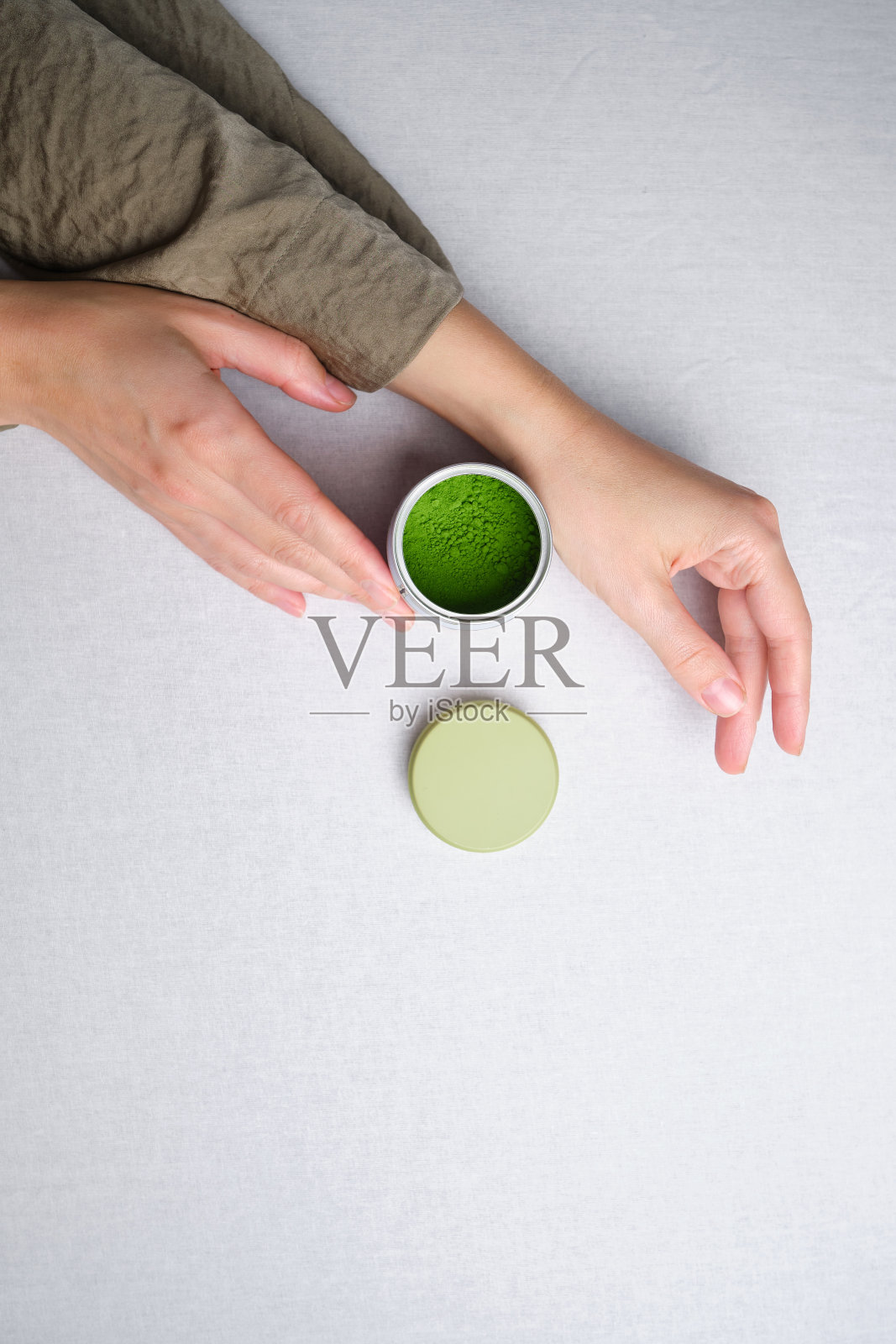 抹茶绿茶粉在一个女孩的手中。有机绿色抹茶仪式。抹茶烹饪，食谱照片摄影图片