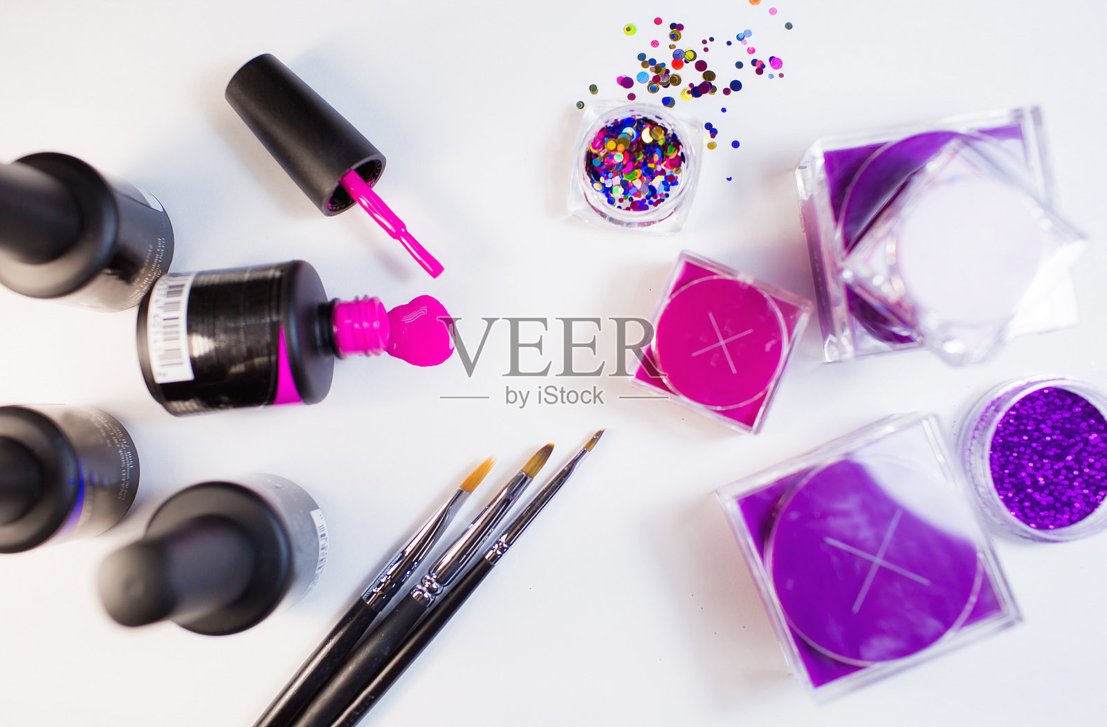 美容工作室。白色背景的修甲材料。刷子，亮片，粉色指甲油。照片摄影图片
