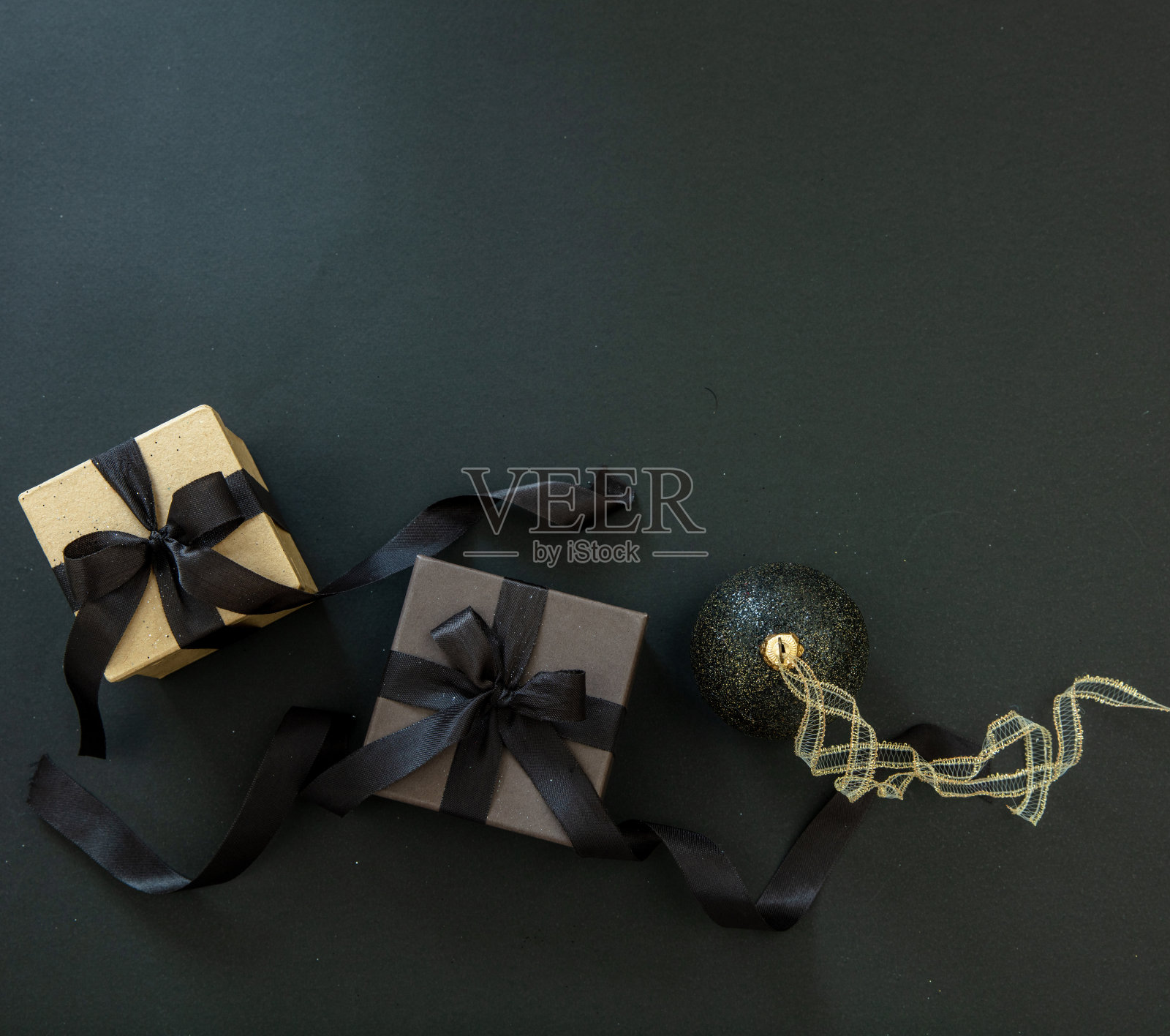 圣诞小玩意，黑色背景上的礼品盒，顶视图复制空间。黑色星期五和圣诞节的概念。照片摄影图片