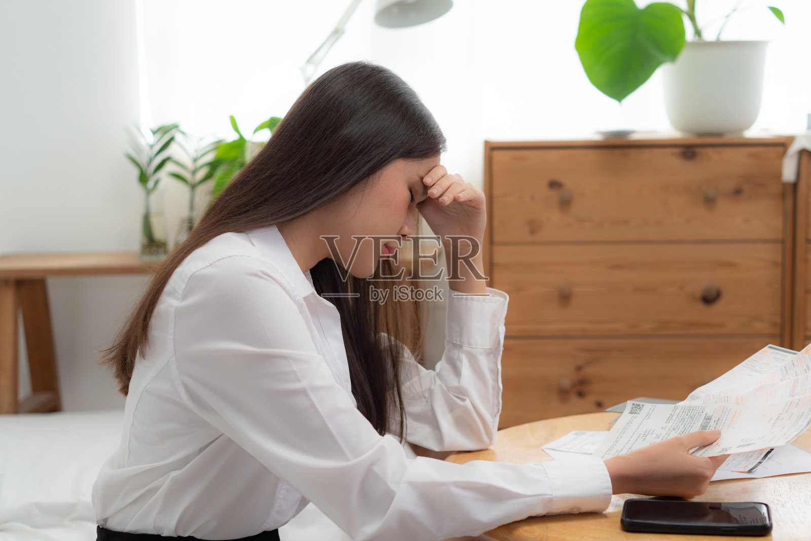 亚洲女性因工作负担和债务而头疼。照片摄影图片