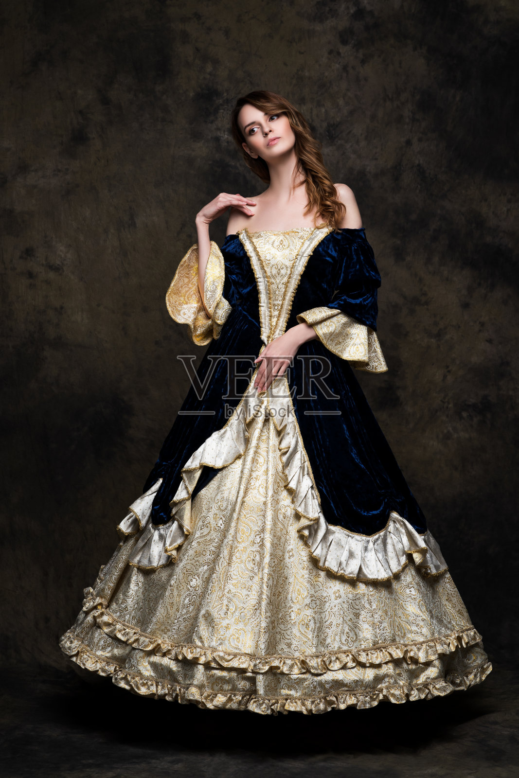 美丽的女人在文艺复兴时期的皇家服装在抽象的黑色背景照片摄影图片