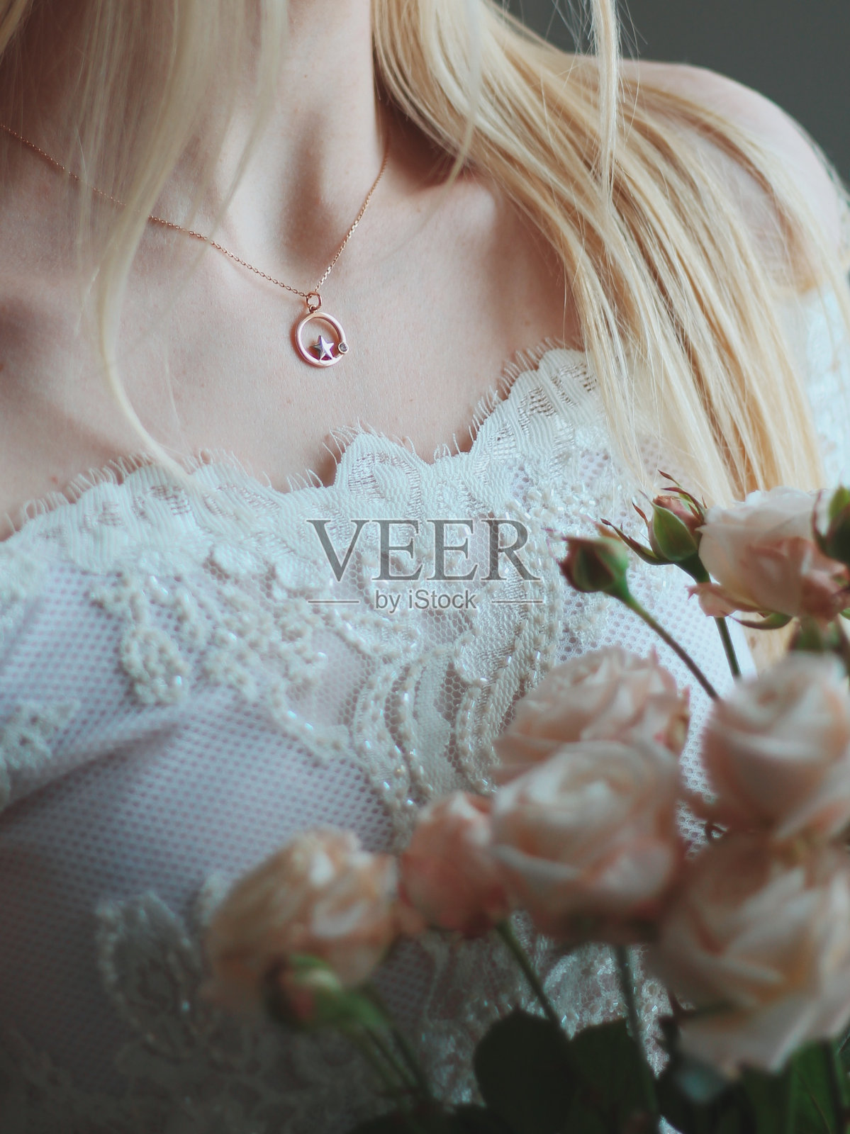 新娘戴着美丽的金项链，手持一束玫瑰的特写镜头照片摄影图片