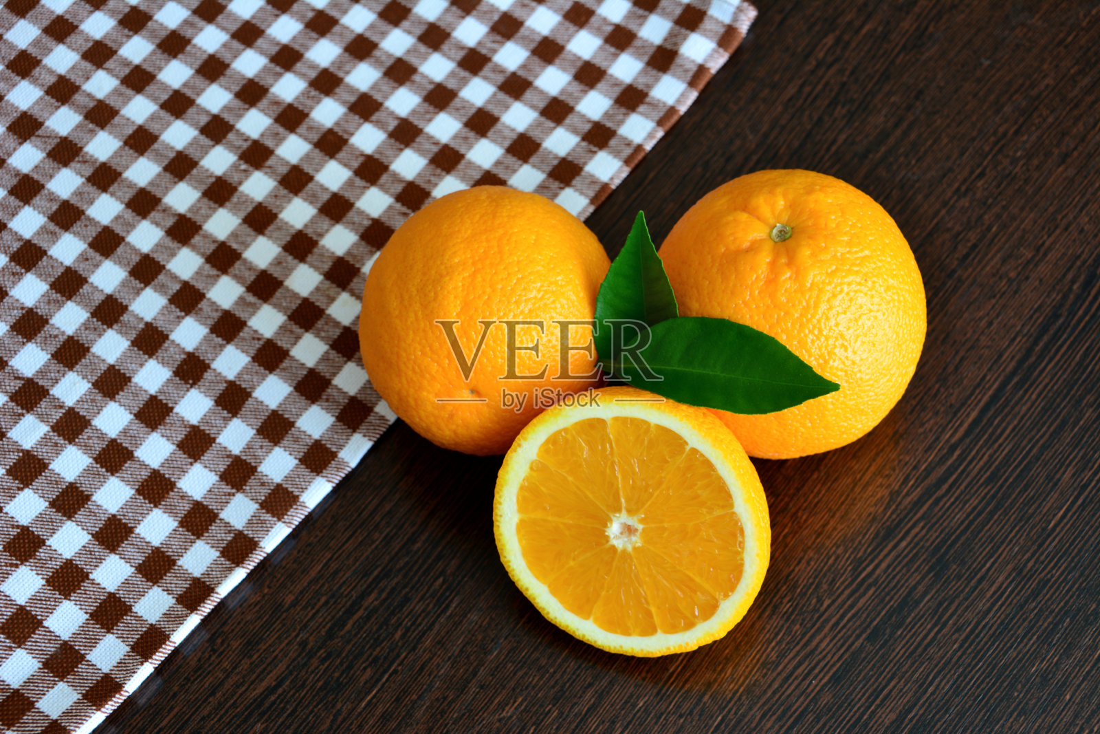 一组新鲜的花园橙子放在木桌上，用桌布，特写照片摄影图片