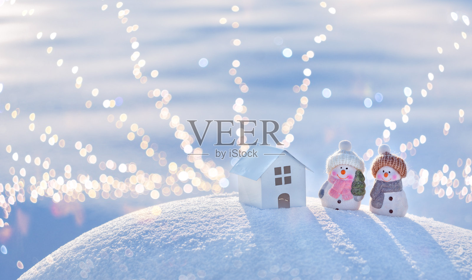 圣诞和新年贺卡用空格复制。快乐的两个雪人站在阳光明媚的冬日小山的圣诞风景上。照片摄影图片