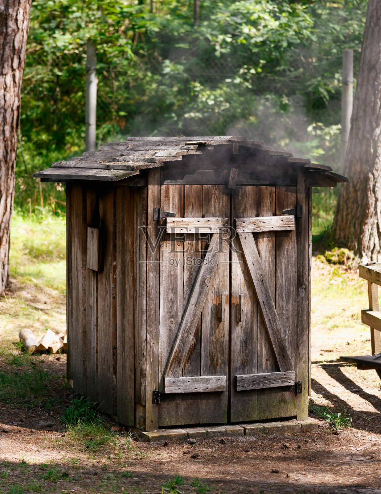 在木制的烟屋里抽烟，自制的烟。在熏制室里做美味可口的熟食。照片摄影图片