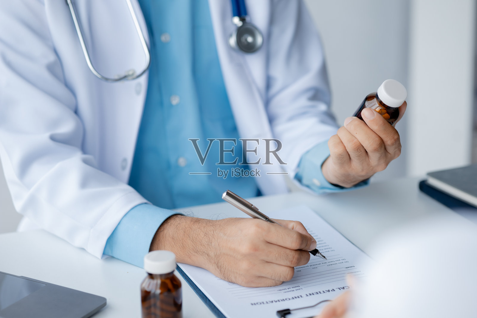 医生是在病人的医生进行检查和诊断后，由药剂师进行治疗概念和对症用药配药后，向病人推荐药物。照片摄影图片