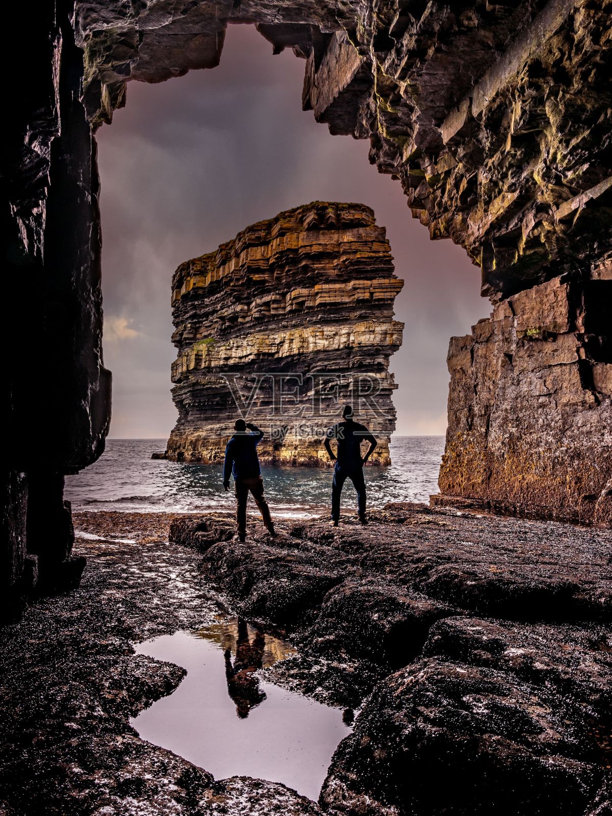 夕阳下小男孩在海边散步的垂直镜头照片摄影图片