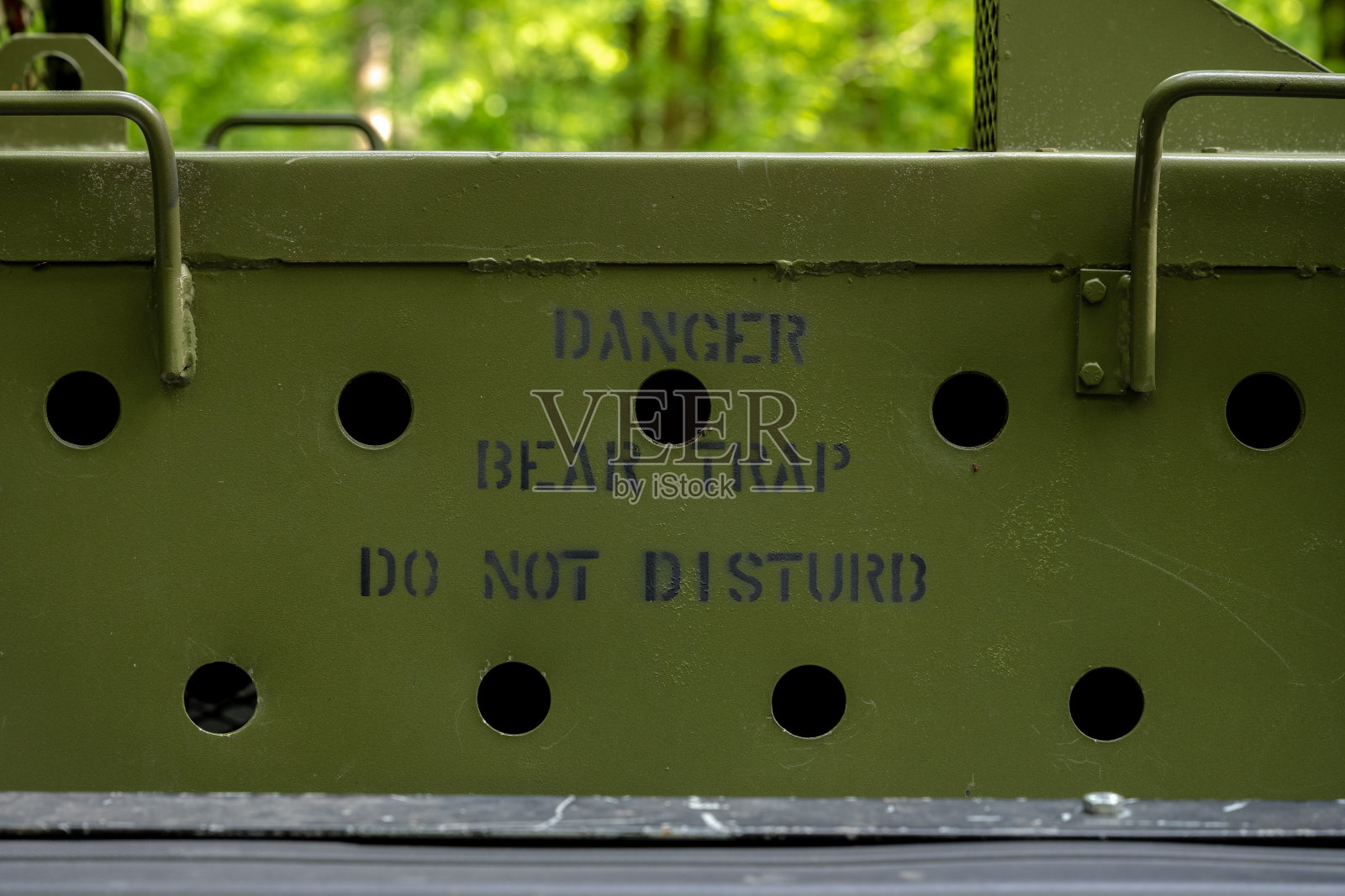 危险捕熊陷阱请勿打扰喷涂在绿色金属盒照片摄影图片