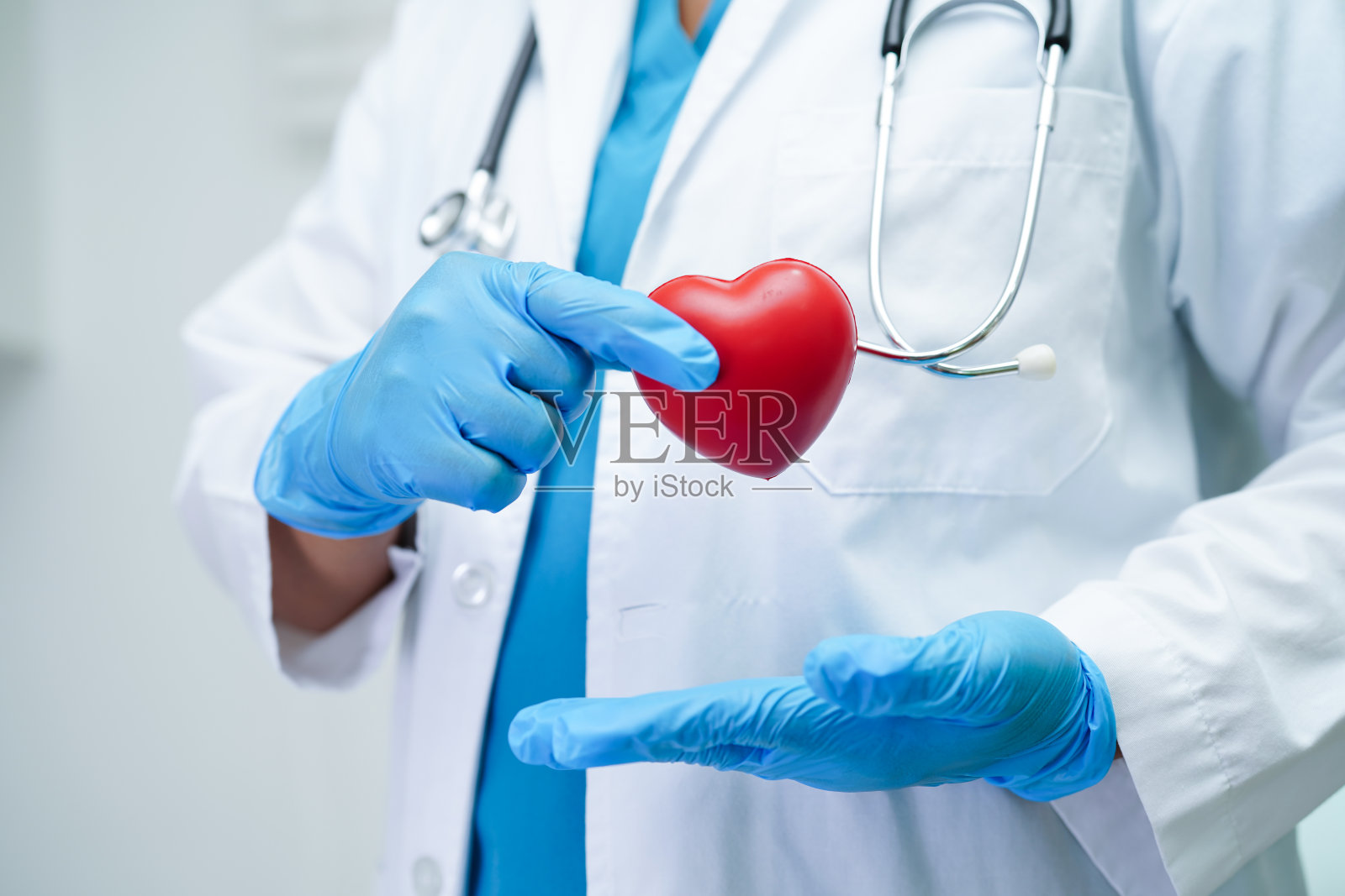 亚洲女医生在医院拿着红心保健康。照片摄影图片