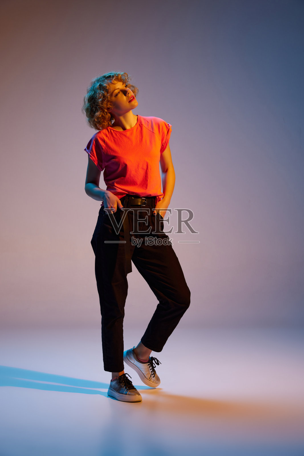 时尚美丽的年轻红发女子的肖像在霓虹灯的黑暗工作室背景上摆姿势孤立。人的情感，面部表情，美的概念。照片摄影图片