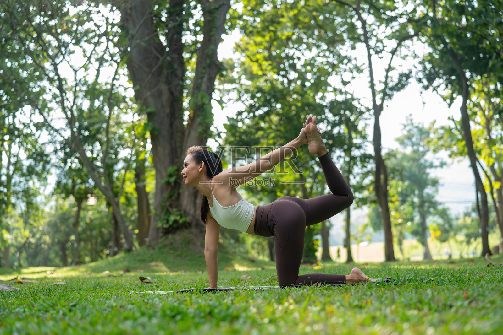 亚洲苗条女子独自在公园锻炼，锻炼累了，玩瑜伽概念照片摄影图片