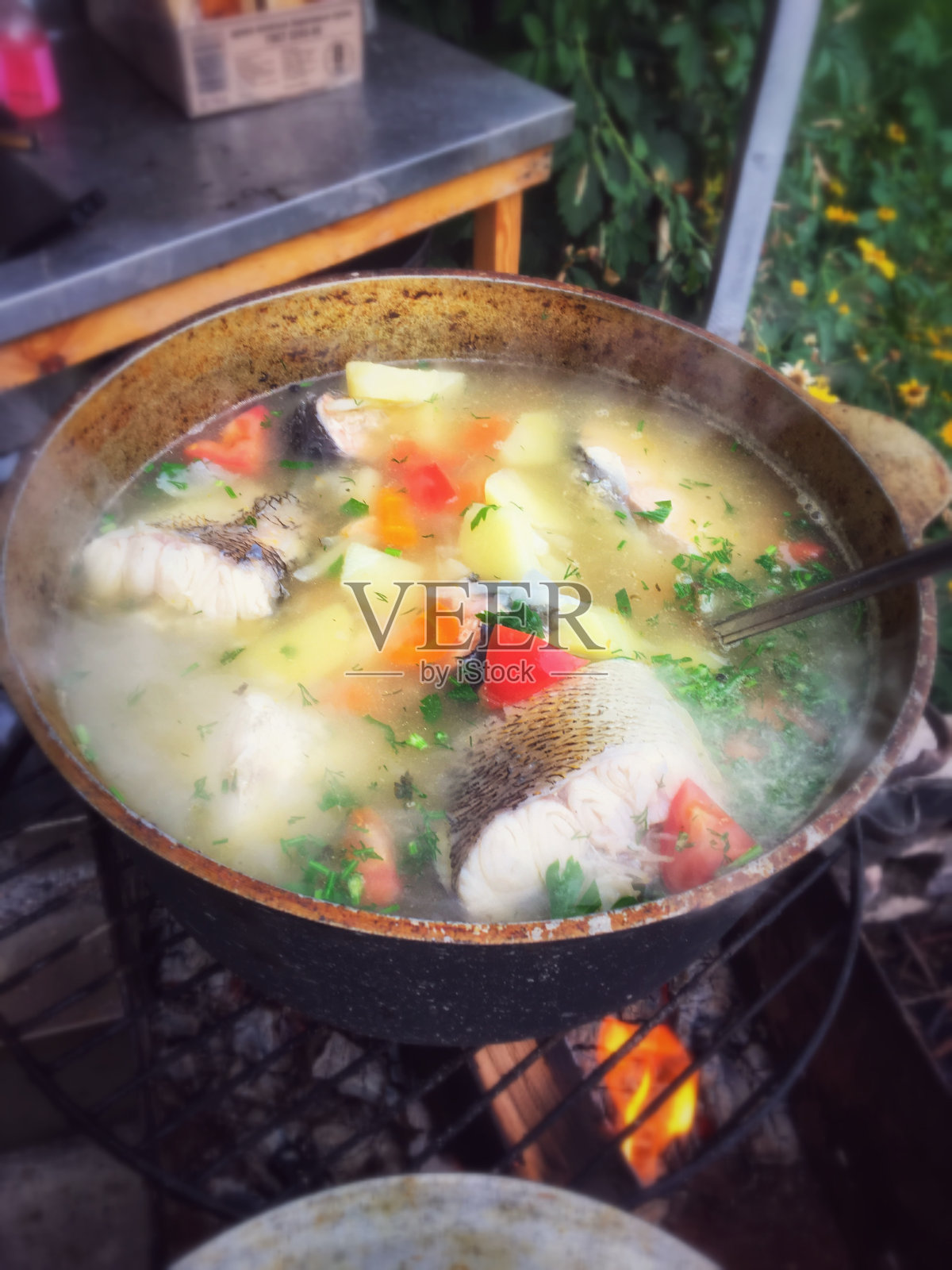 用大块的鱼和蔬菜在大锅上用火煮的鱼汤照片摄影图片