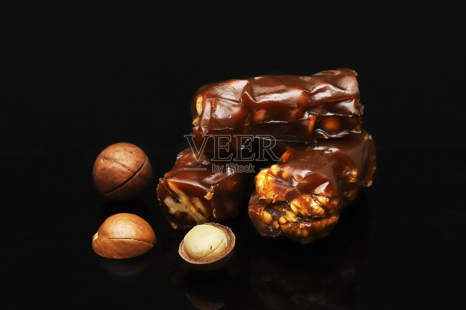 在一间黑暗的房间里，不同颜色的丘奇拉和削了皮的核桃的边缘。浅景深照片摄影图片